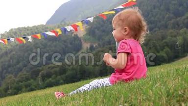 在炎热的夏日，小宝宝坐在山上的绿草上。 全高清。 1920x1080